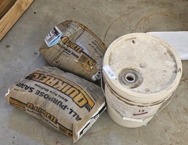bucket of sand with two bags