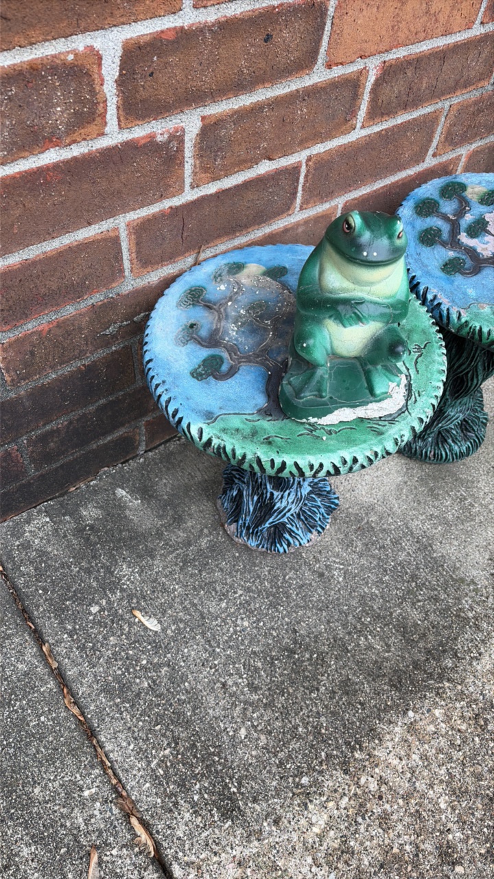 Two decorative outdoor tables with tree design and frog statue