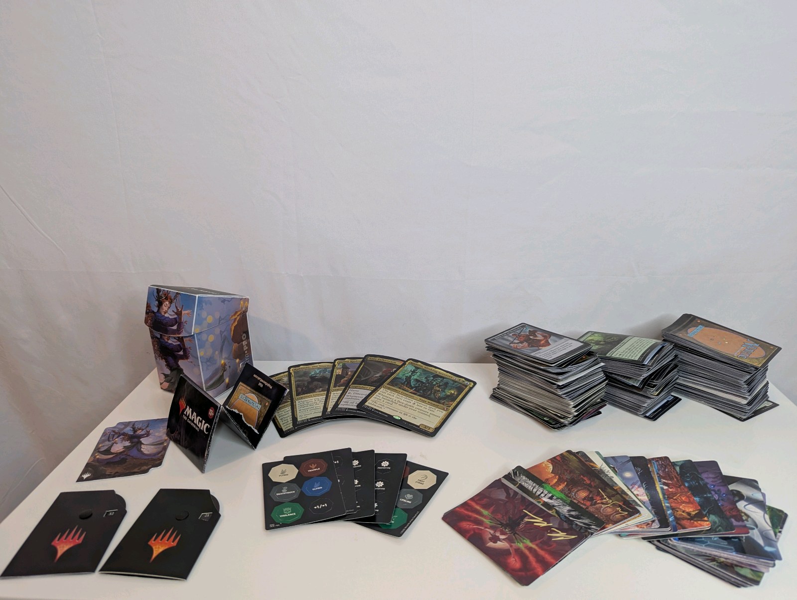 Unsorted Magic The Gathering cards, including various decks, stacks of sorted cards, and tokens or counters