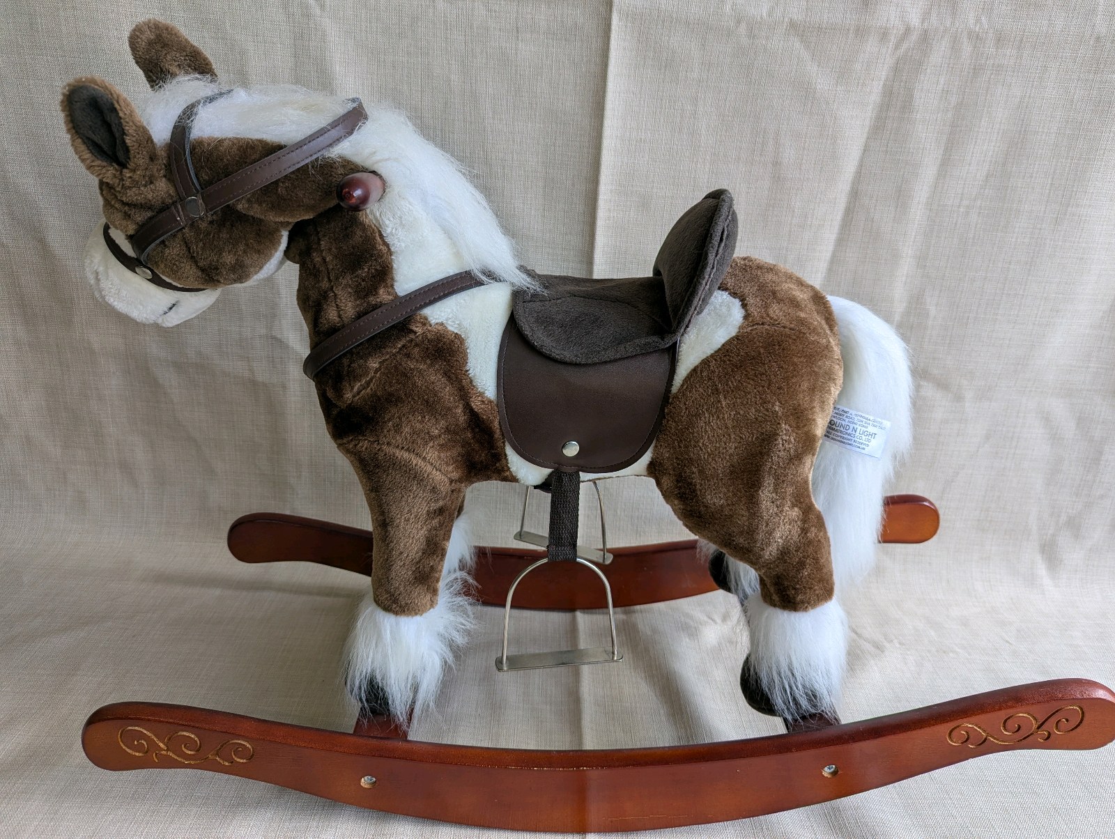 Vintage Sound N Light plush rocking horse features a brown and white pinto design with a wooden base, works